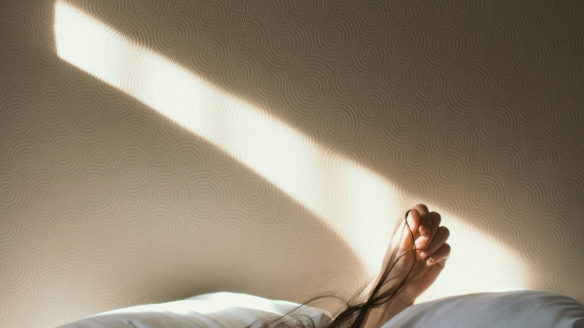 Woman lying on bed. — a Sleep Finally guide to Waking Up Hot at Night: Common Causes.
