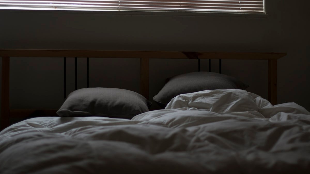 Empty white and gray bed set. — a Sleep Finally guide to What Is Sleep Restriction in CBT-I? The Honest Version.