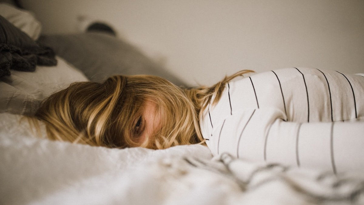 Woman lying on bed. — a Sleep Finally guide to Chronic Insomnia Definition: Three Nights, Three Months.