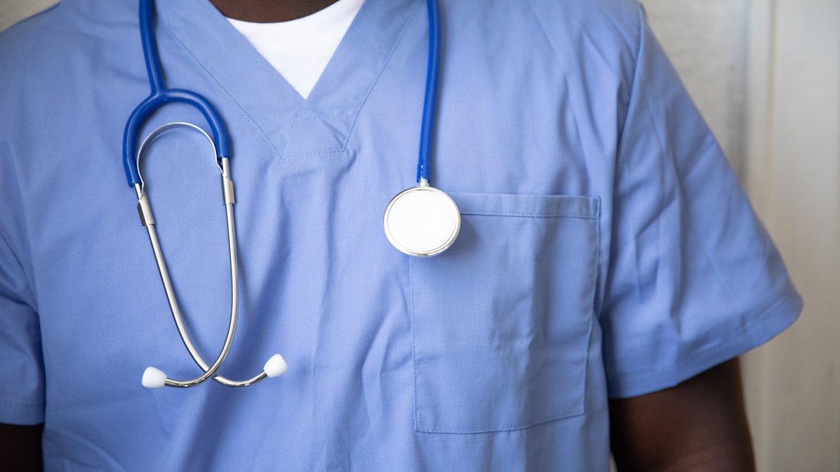 A person in blue medical scrubs with a stethoscope around their neck. — a Sleep Finally guide to When to Ask Your Doctor About Shift Work Sleep.