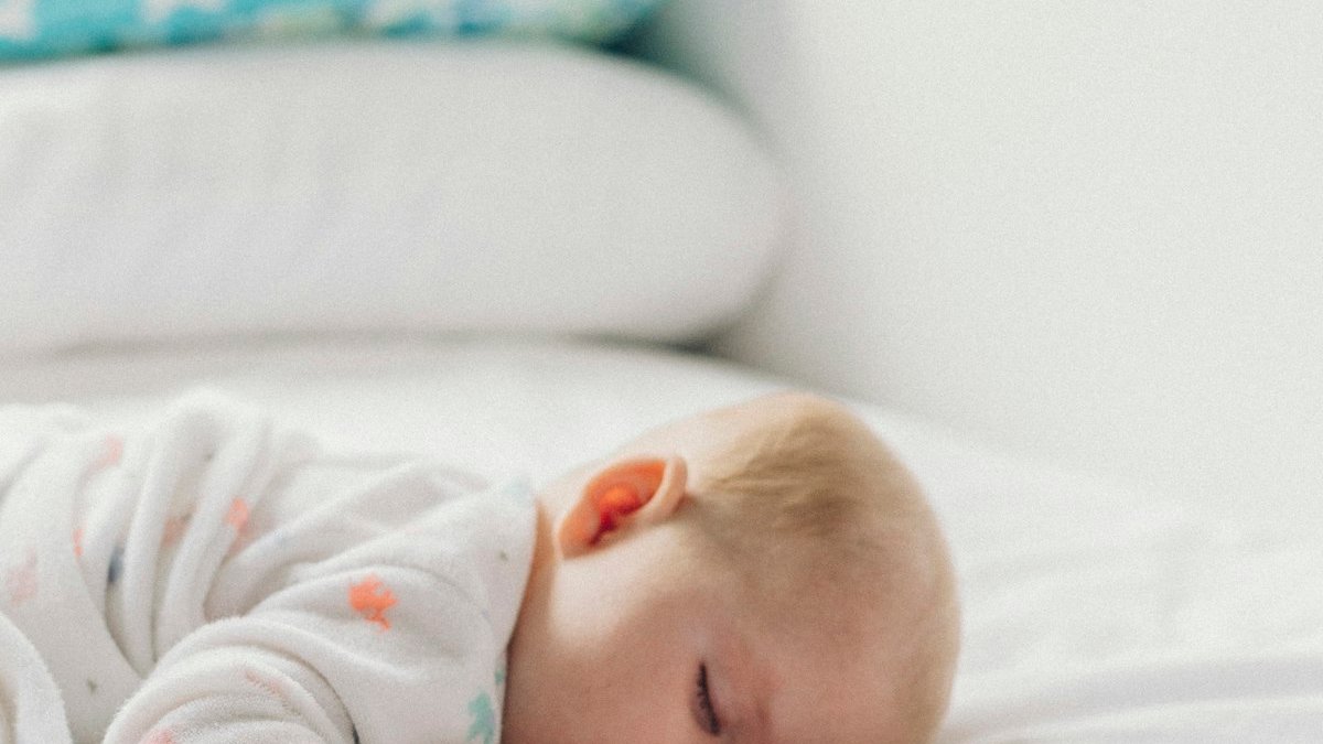 Photo of baby laying on bed. — a Sleep Finally guide to Why 20-Minute Naps Beat 30-Minute Naps.