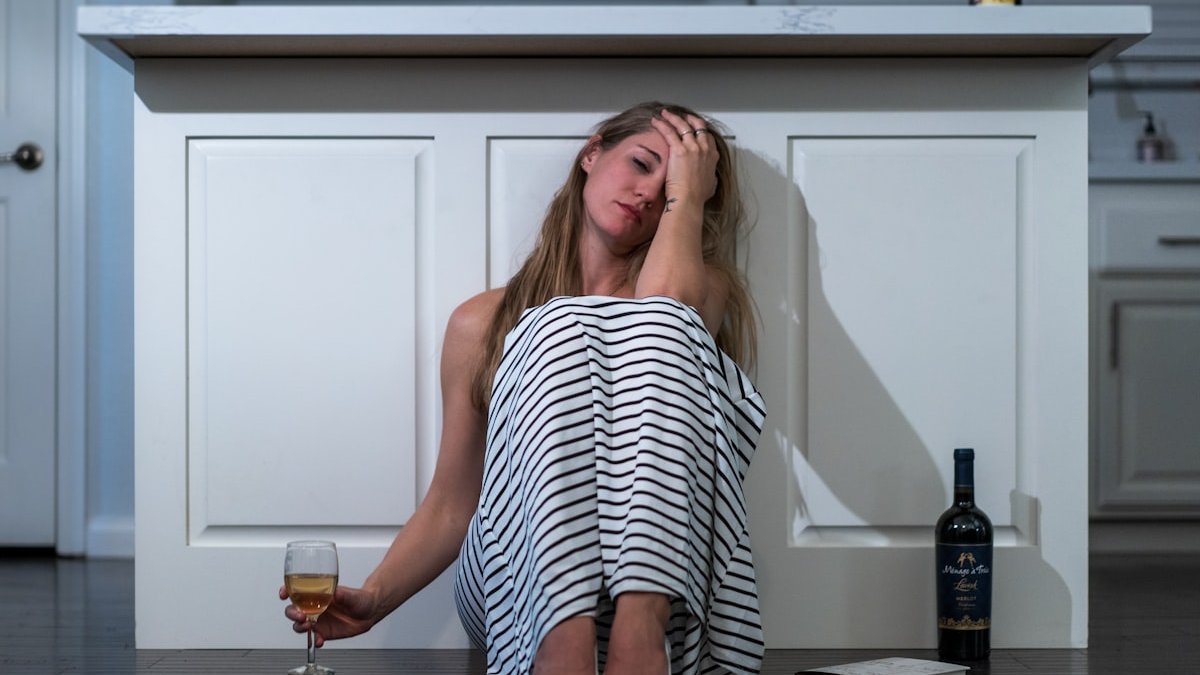 Woman in black and white stripe tank top sitting on chair. — a Sleep Finally guide to Why Alcohol Wakes You at 3am: The Invoice Explained.
