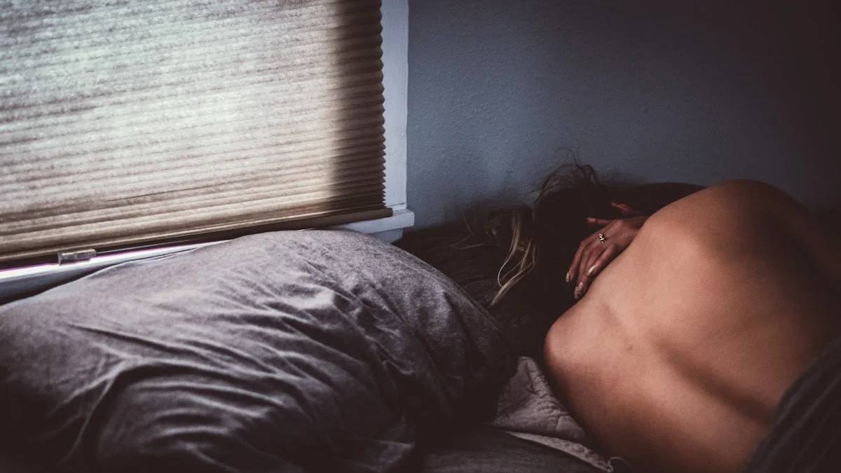 topless woman lying on bed — a Sleep, Finally guide to Why You Wake After Four Hours of Day Sleep