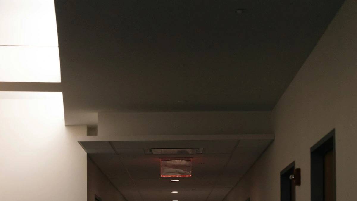 a long hallway with a red light on the ceiling — a Sleep, Finally guide to Why You Wake to Pee at Night, and When It's a Red Flag