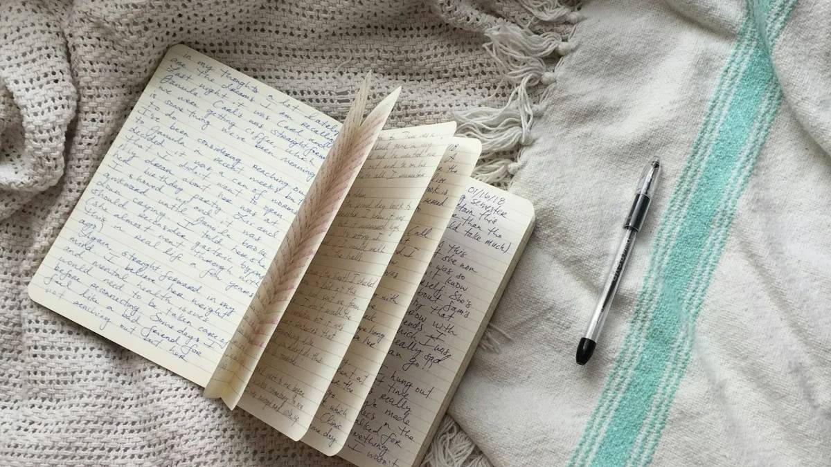a book and a pen on a bed — a Sleep, Finally guide to Worry Journals for 3am Anxiety: Do They Help